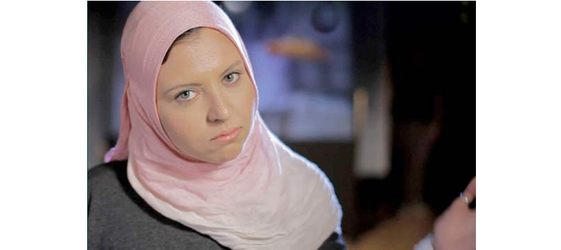 Still image from the buSSy monologues - showing a woman in a pink headscarf