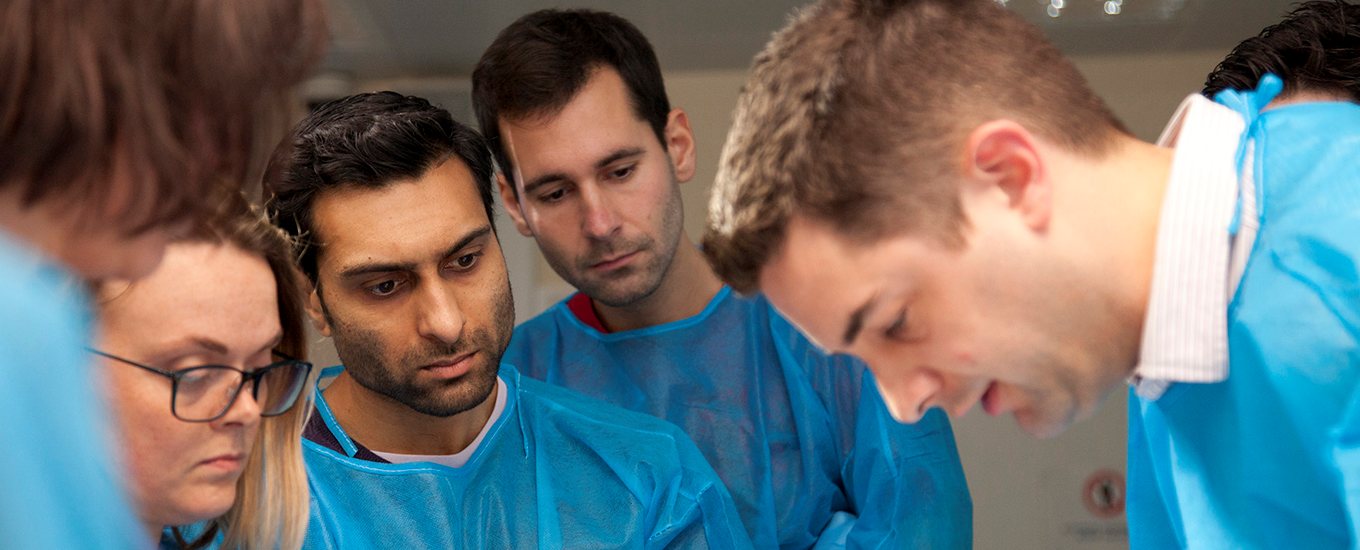 cardiology students wearing scrubs in surgery setting