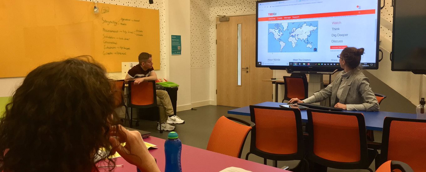 Students in a classroom looking at a map on a screen
