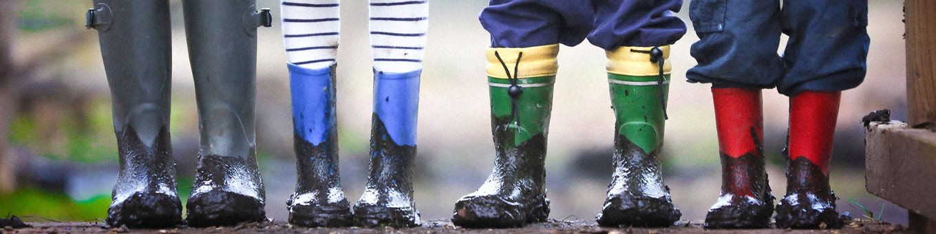 Three pairs of wellies covered in mud