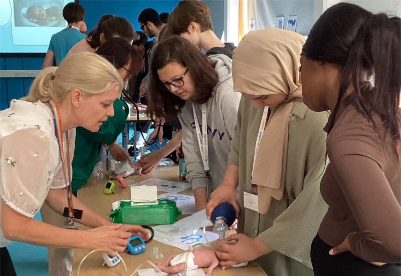 Students gathered around a table at a clinical skills session