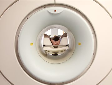 a person laying down in a pet scanner machine