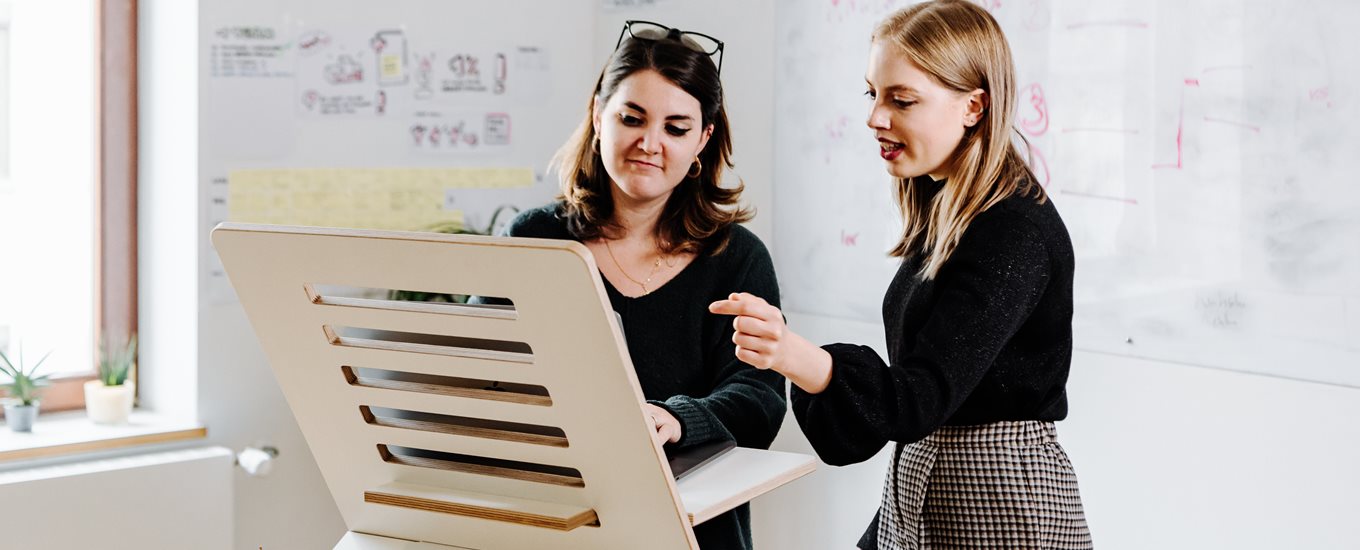 Two women working upright on standing desk