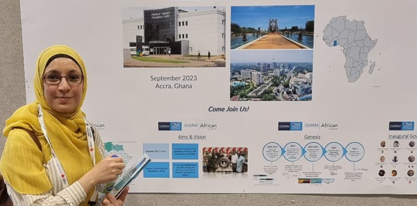 Samira Bouyagoub at ISMRM conference in front of a poster on a display board