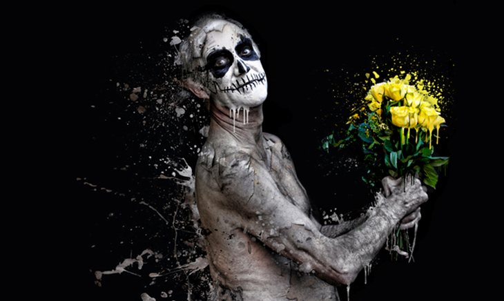 BEAUTIFUL DECAY by Danielle Tunstall - a painting showing a naked figure with skull face-paint holding a melting bouquet of yellow roses