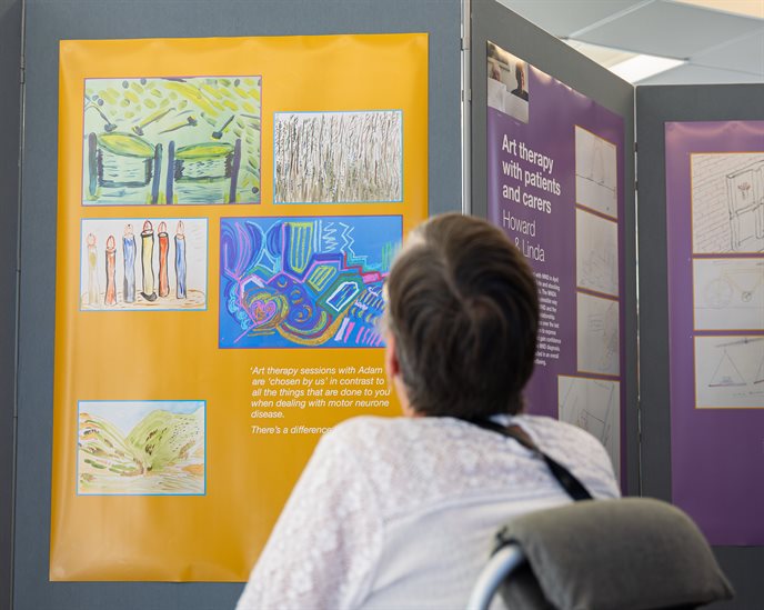 A photo of a person looking up at pieces of artwork at an exhibition