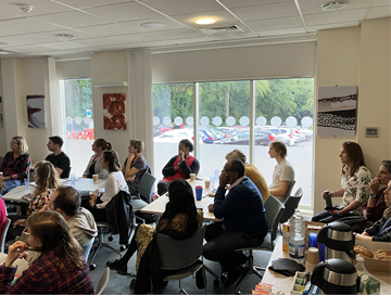 A group of people in a workshop listening to a talk