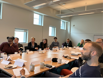 A group of people in a workshop listening to a talk