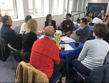 A group of researchers sat round a table having a discussion