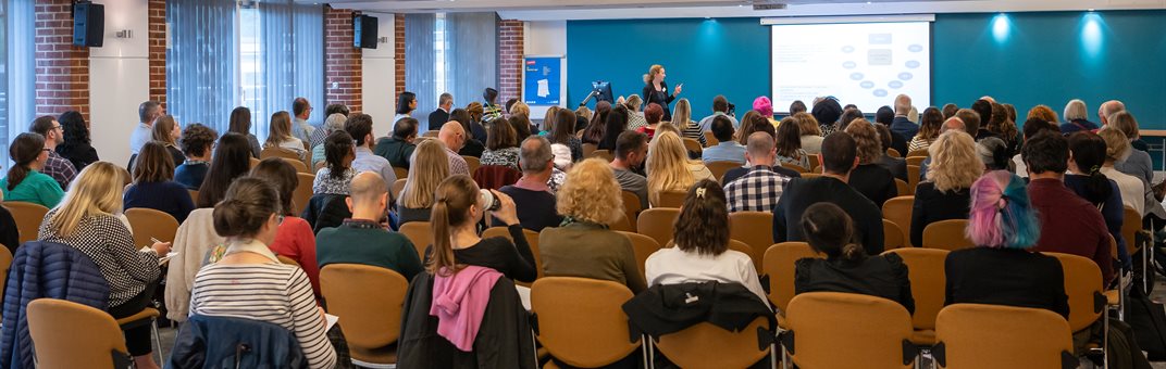 A group of people in a talk at the HRP conference