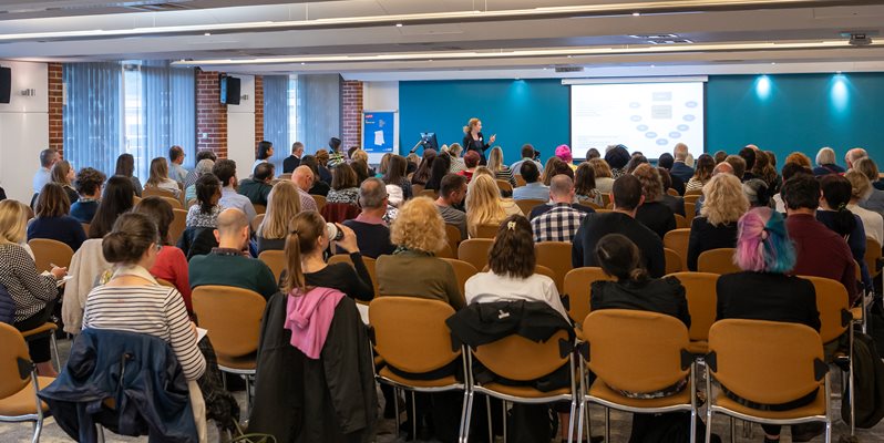 A group of people in a talk at the HRP conference
