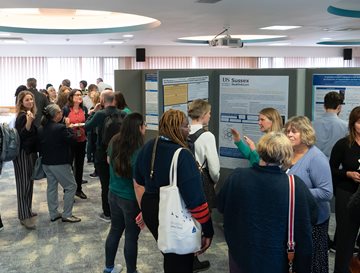 People talking next to poster display at a conference