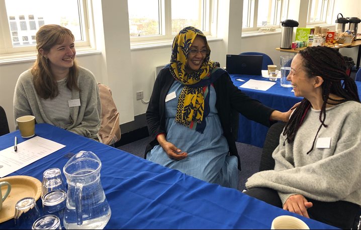 Three people sitting at a table having a discussion