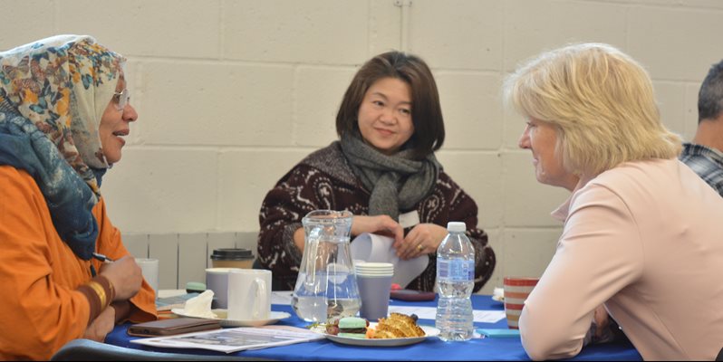 Three people talking at a research event