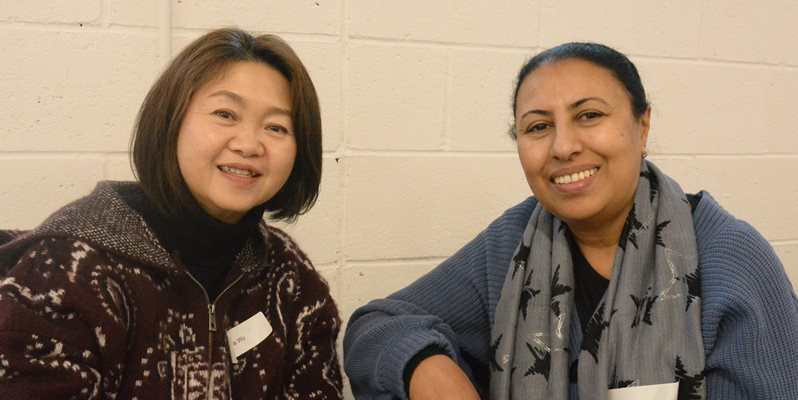 Two people smiling sat together at an event