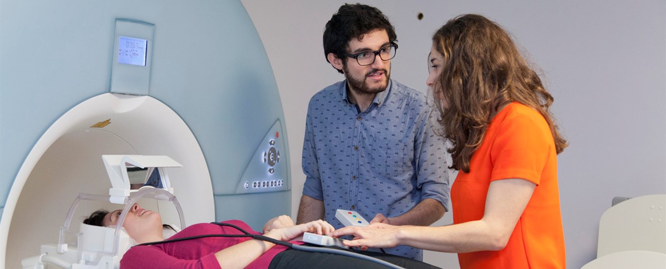 Researchers in discussion over a patient about to go into an MRI scanner