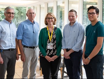 A group of researchers in a line at a MND network meeting in 2023