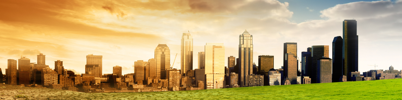 A skyline of buildings half against a blue sky with green grass and half with dry floors and an orange sky