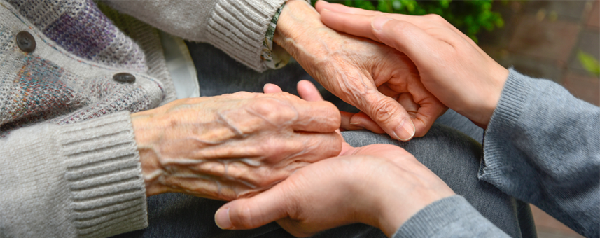 A young person holding an older persons hand