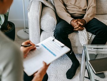 A doctor talking to a patient with a notepad in hand