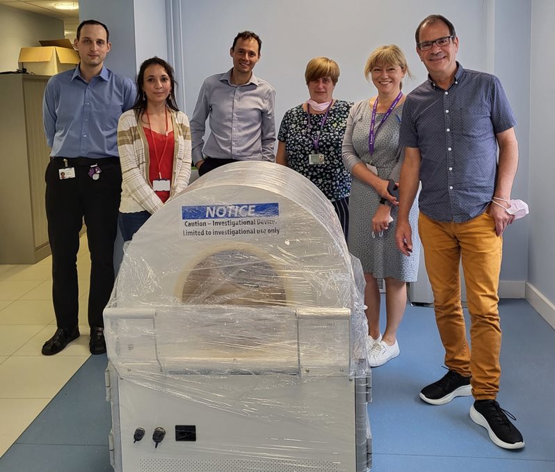 People stood behind a large clinical scanner