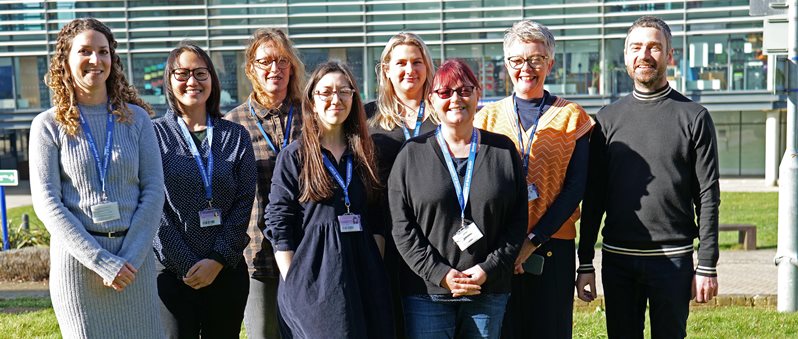 Photo of staff standing outside on the grass together