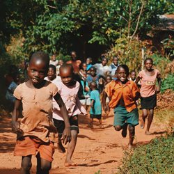 A group of children walking and running towards the camera