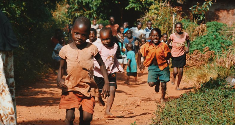 Children running through a village