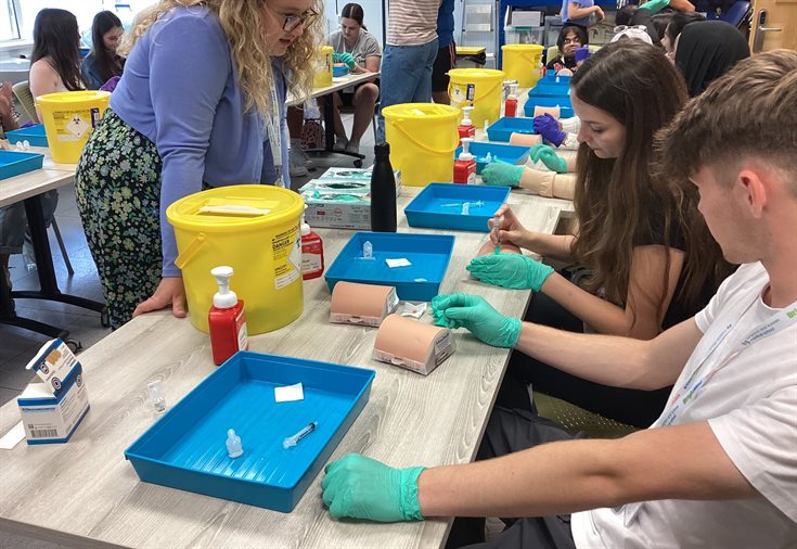 Students sitting at a table at a clinical skills session