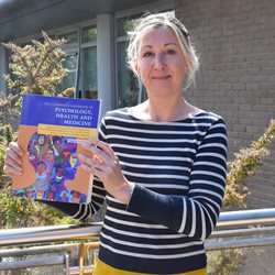 Prof Carrie Llewellyn with her book