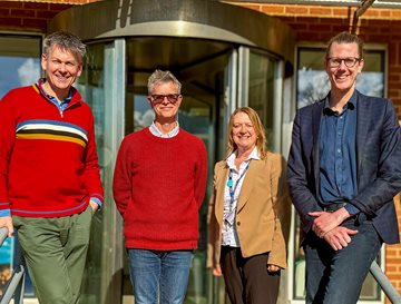 Image of researchers standing outside the research building on the steps