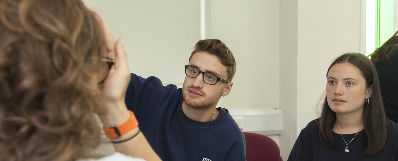 A male student examines a female patient educator's eyes