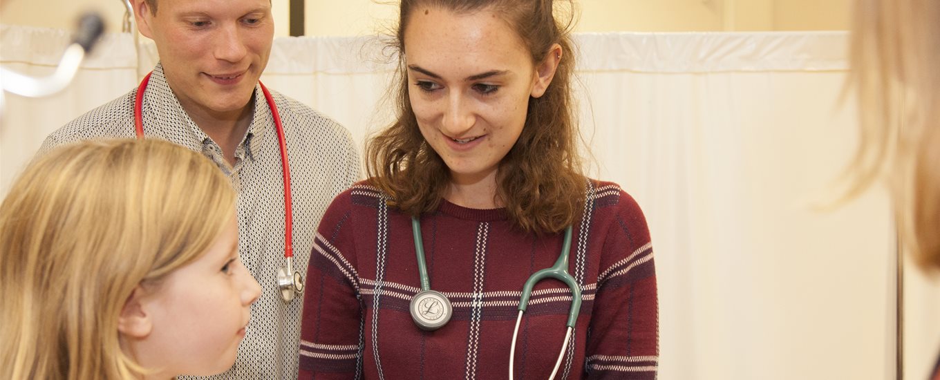 Male doctor, female medical student and child patient