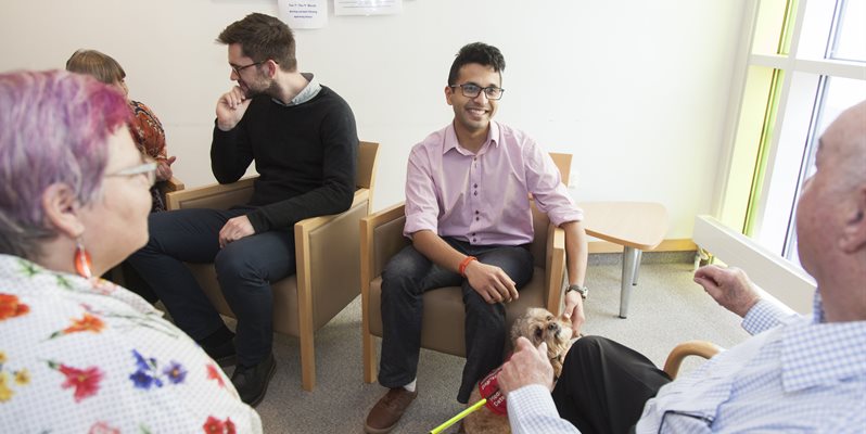 A photo showing members of a Patient educator group and medical students sat together talking