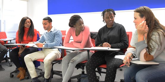 Postgraduate students in a classroom chatting