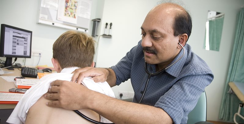 Prof Somnath Mukhopadhyay listens to a child's back with a stethoscope