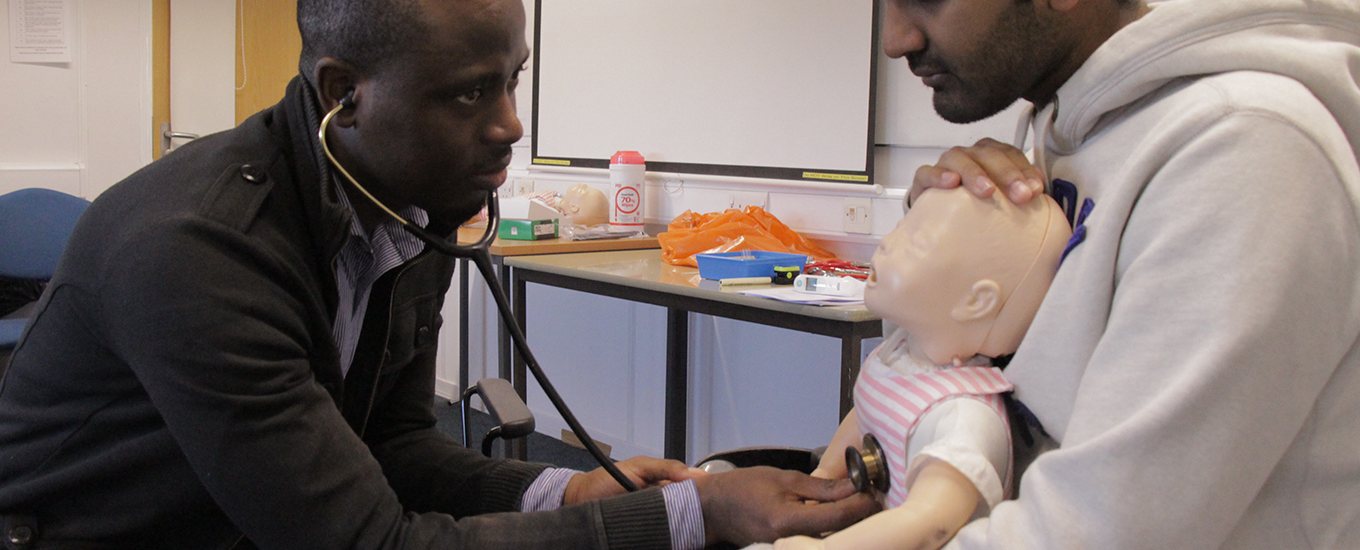 student listening to a mannequins heartbeat