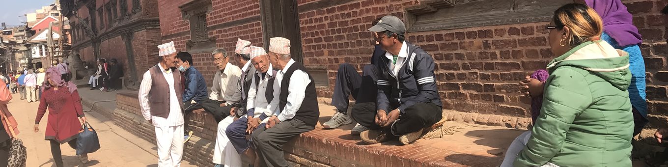 A group of people sitting on a wall in Nepal