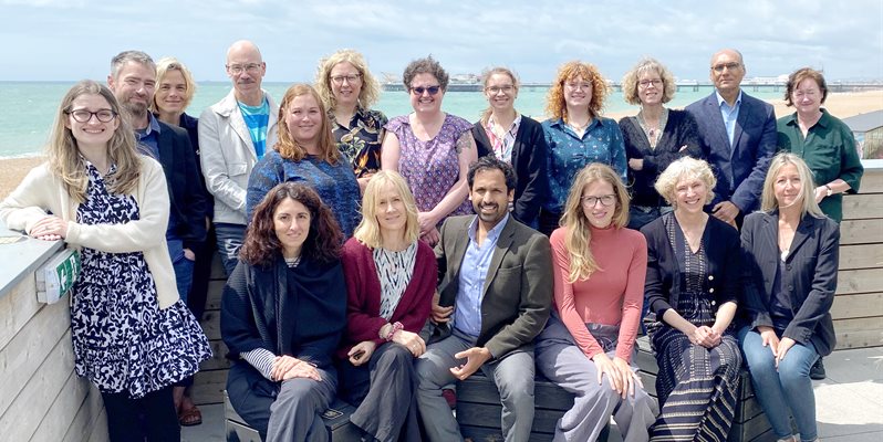 A team of people sat against a wall on Brighton seafront