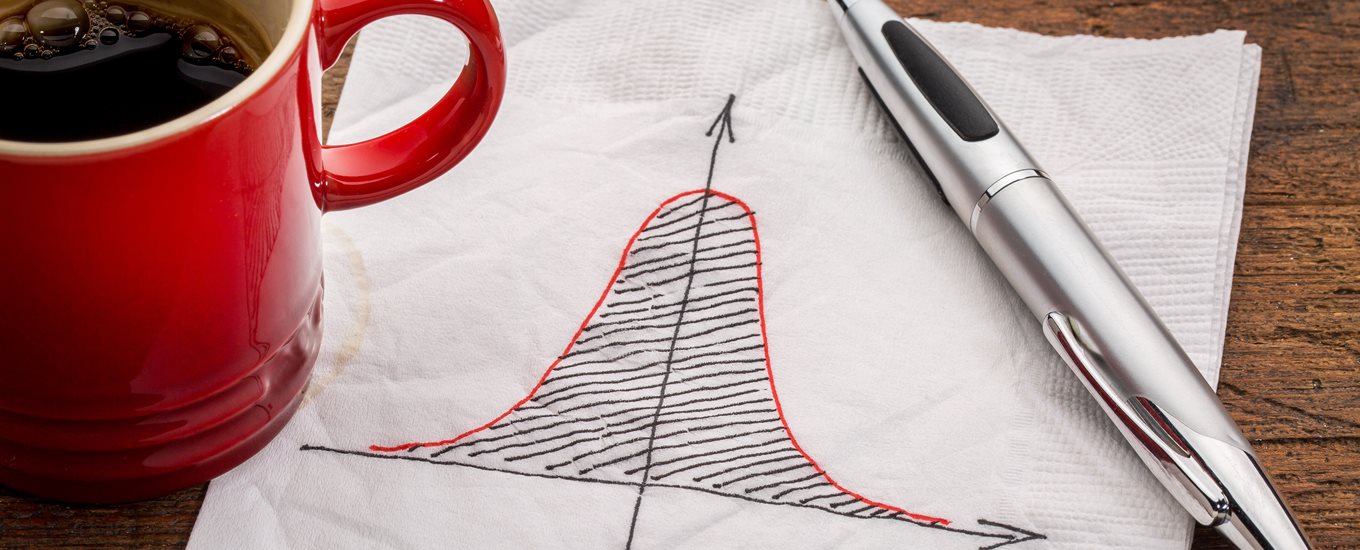 A red coffee mug, napkin with statistical drawing and a pen on a brown table
