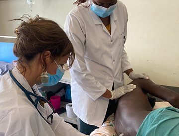 Two nurses treating a patient with am injection in a clinical setting