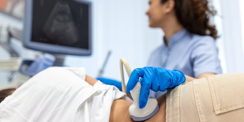 Doctor conducts ultrasound examination of patientv kidneys. Internal organs ultrasound concept. female's lower back diagnosis carried out with the use of an ultrasound
