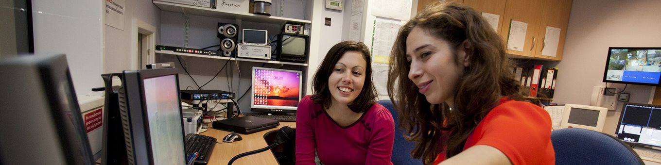 Two students looking working at a computer together