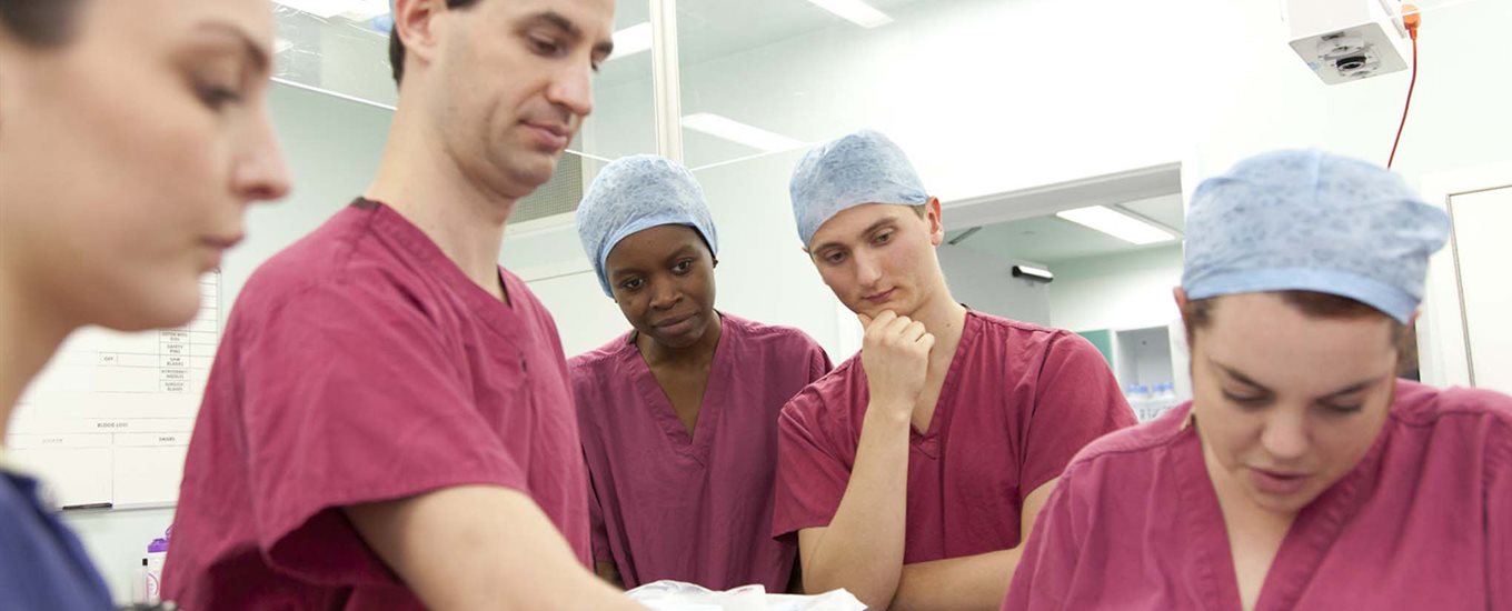 Students watch a surgeon in theatre