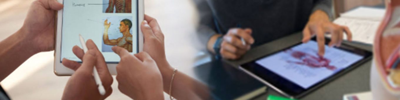 Fingers pointing to an anatomical image on an iPad, another student sitting in the background