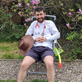 A photo showing Jack Whiting sitting on a chair in a garden