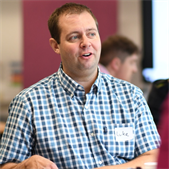 Luke West, LEF fellow 2021-22, pictured sitting at a table in conversation during a workshop