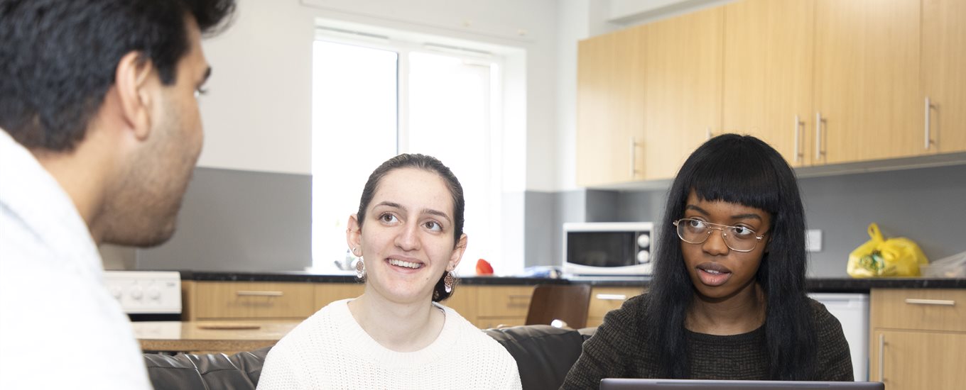 Three students sitting in the kitchen in halls