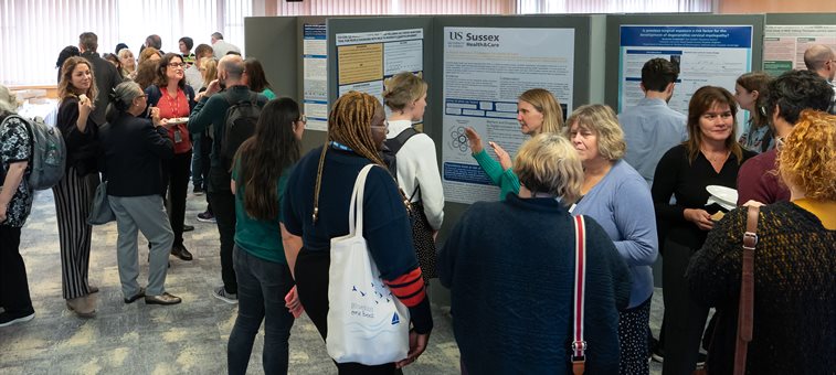 People stood around talking and looking at posters at an event
