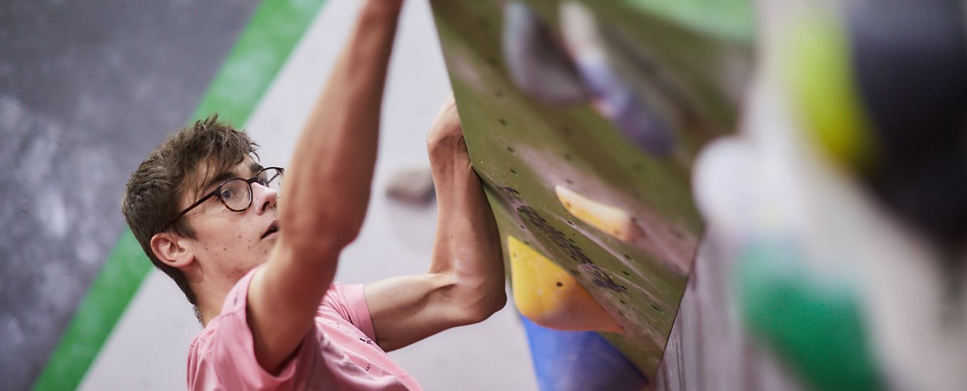 Student climbing on a wall at climbing venue